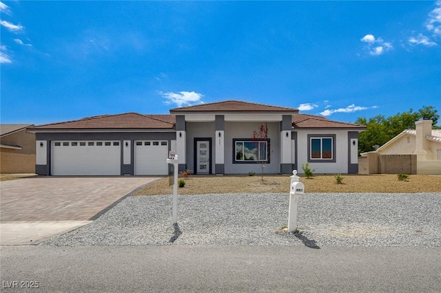 2110 S Manzanita Dr, Pahrump, NV 89048 - view of front facade featuring a tile roof, a garage, driveway, and stucco siding