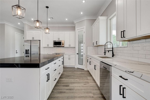 2110 S Manzanita Dr, Pahrump, NV 89048 - kitchen featuring crown molding, white cabinets, a kitchen island, a sink, and stainless steel appliances