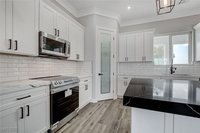 2110 S Manzanita Dr, Pahrump, NV 89048 - kitchen with light stone countertops, light wood-type flooring, white cabinets, appliances with stainless steel finishes, and a sink