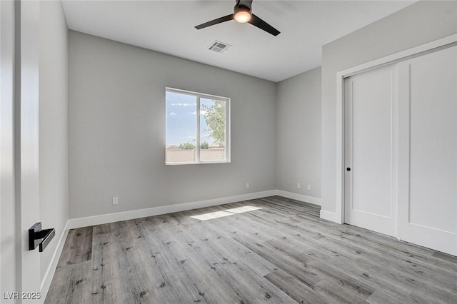 2110 S Manzanita Dr, Pahrump, NV 89048 - unfurnished bedroom featuring visible vents, baseboards, a closet, ceiling fan, and wood finished floors