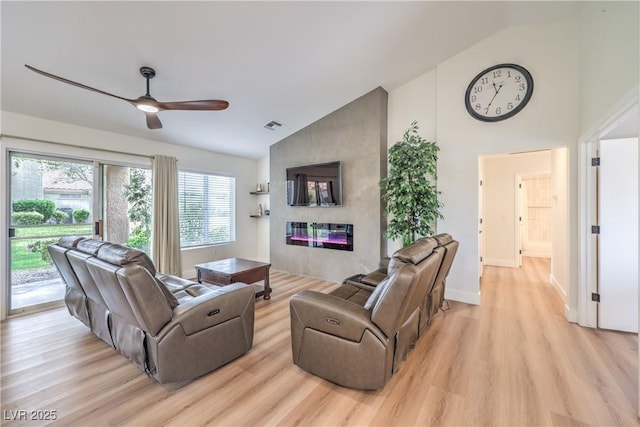 8513 Glenmount Dr, Las Vegas, NV 89134 - living room featuring high vaulted ceiling, a fireplace, light wood-type flooring, a ceiling fan, and visible vents