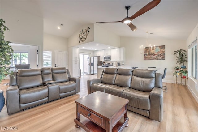 8513 Glenmount Dr, Las Vegas, NV 89134 - living room with light wood-style flooring, ceiling fan with notable chandelier, and high vaulted ceiling