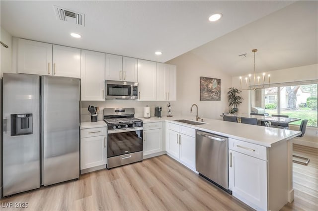 8513 Glenmount Dr, Las Vegas, NV 89134 - kitchen featuring a peninsula, white cabinetry, visible vents, stainless steel appliances, and a sink