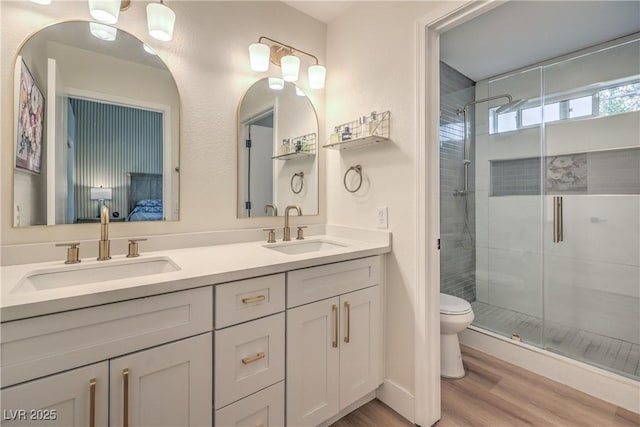 8513 Glenmount Dr, Las Vegas, NV 89134 - bathroom with a sink, double vanity, a stall shower, and wood finished floors