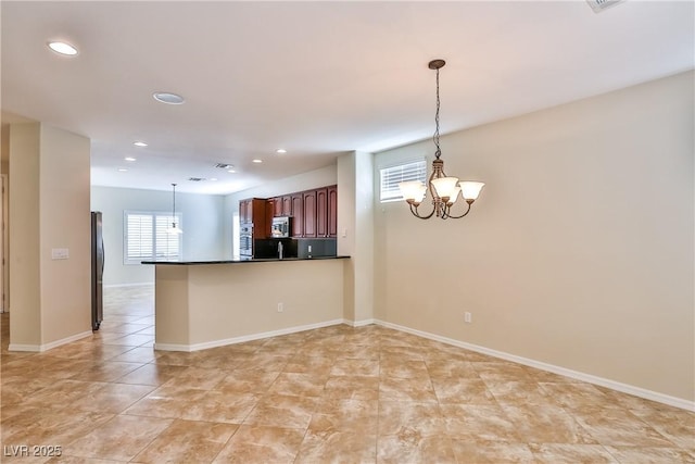 2229 Suffron Hills Ct, Henderson, NV 89044 - kitchen featuring pendant lighting, freestanding refrigerator, a peninsula, dark countertops, and a notable chandelier
