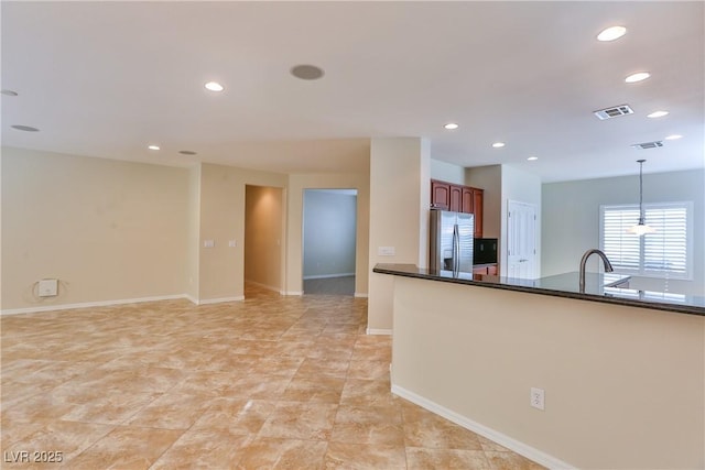2229 Suffron Hills Ct, Henderson, NV 89044 - kitchen with stainless steel fridge with ice dispenser, hanging light fixtures, dark countertops, and recessed lighting