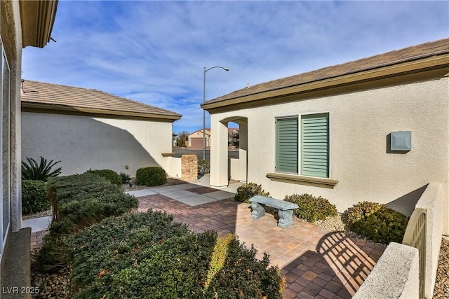 2229 Suffron Hills Ct, Henderson, NV 89044 - view of side of home with a patio, stucco siding, and a tiled roof