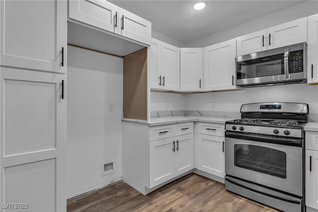 2851 S Valley View Blvd Unit 1098, Las Vegas, NV 89102 - kitchen with stainless steel appliances, white cabinetry, wood finished floors, light stone counters, and recessed lighting