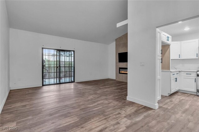 2851 S Valley View Blvd Unit 1098, Las Vegas, NV 89102 - unfurnished living room with light wood-style floors, a tile fireplace, and baseboards