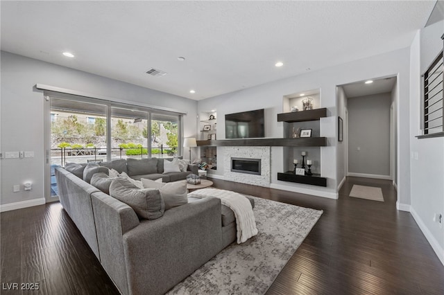12665 Cooks Bay Ct, Las Vegas, NV 89141 - living room featuring a glass covered fireplace, baseboards, recessed lighting, dark wood-style floors, and visible vents