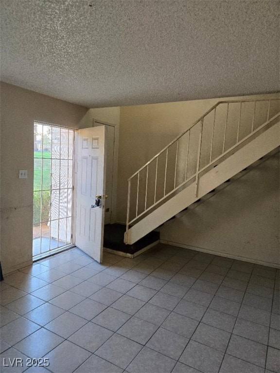 foyer entrance featuring tile patterned flooring and a textured ceiling