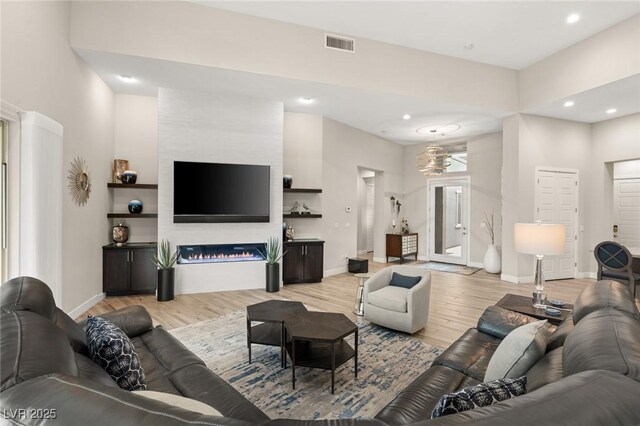 living room with visible vents, light wood-style flooring, recessed lighting, and baseboards