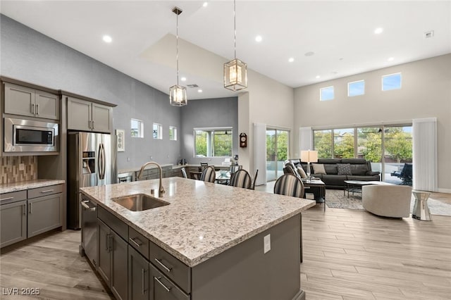 kitchen featuring recessed lighting, a high ceiling, stainless steel appliances, and a sink