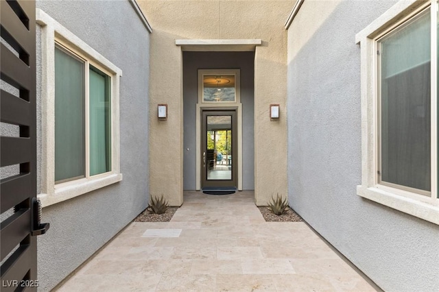 doorway to property featuring stucco siding