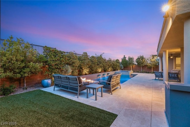 pool at dusk featuring a patio, outdoor lounge area, an outdoor pool, a fenced backyard, and a yard