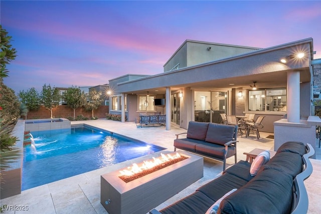 pool featuring a patio area, outdoor dry bar, and an outdoor living space with a fire pit