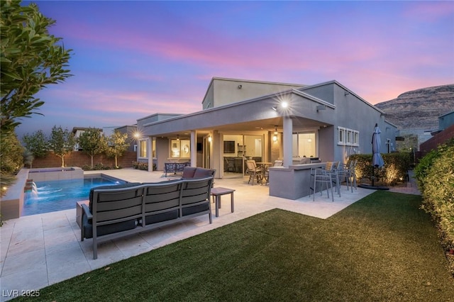 rear view of property with an outdoor living space, a lawn, a patio, outdoor dry bar, and an outdoor pool