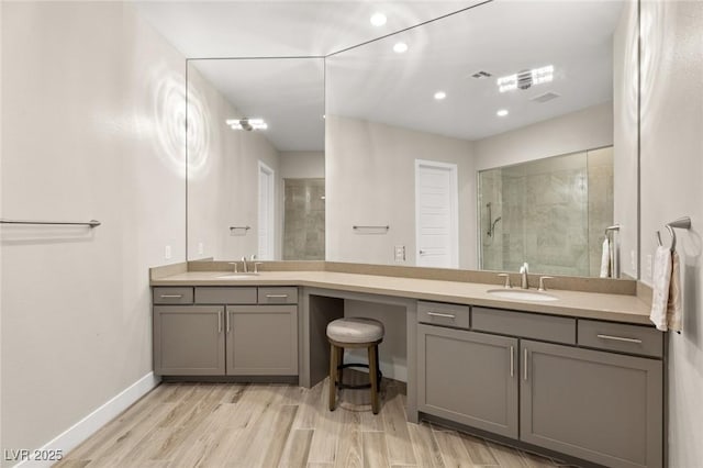 full bath featuring a tile shower, recessed lighting, a sink, double vanity, and baseboards