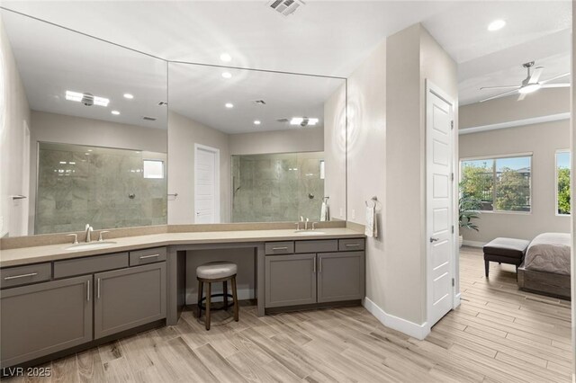 ensuite bathroom featuring visible vents, recessed lighting, vanity, and a tile shower