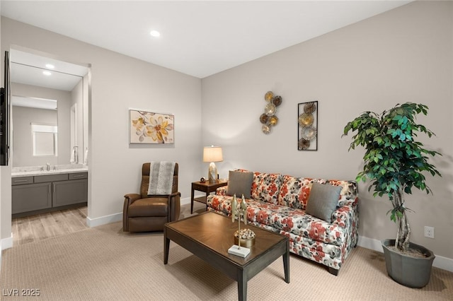 living area with baseboards, light carpet, and recessed lighting