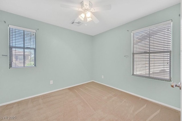 carpeted empty room featuring ceiling fan and baseboards