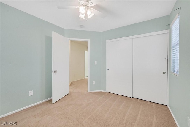 unfurnished bedroom with carpet flooring, a closet, a ceiling fan, and baseboards