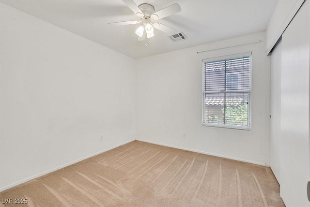 empty room featuring light carpet, ceiling fan, and baseboards