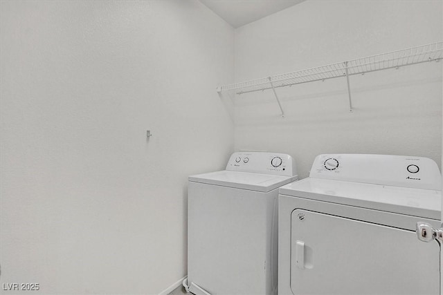 washroom with independent washer and dryer and baseboards