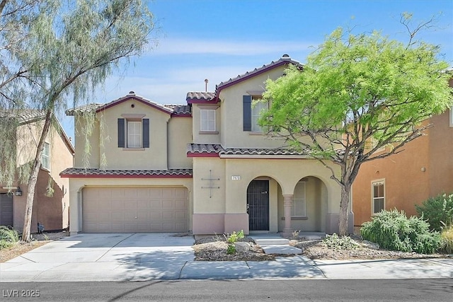 mediterranean / spanish-style home with a tile roof, an attached garage, stucco siding, and driveway