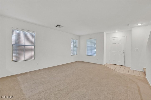 empty room featuring light colored carpet, recessed lighting, and baseboards