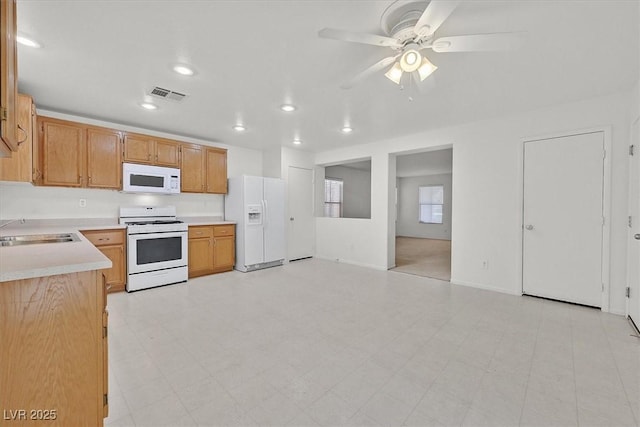 kitchen with white appliances, a sink, light countertops, ceiling fan, and recessed lighting