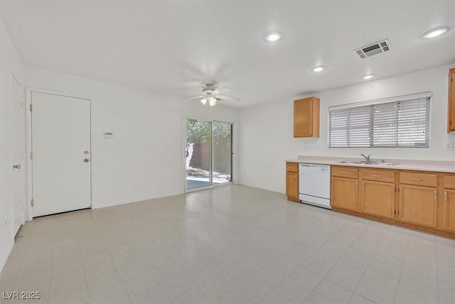 kitchen featuring white dishwasher, a ceiling fan, a sink, light countertops, and recessed lighting