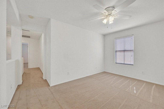 unfurnished room with light colored carpet, a ceiling fan, baseboards, and a smoke detector
