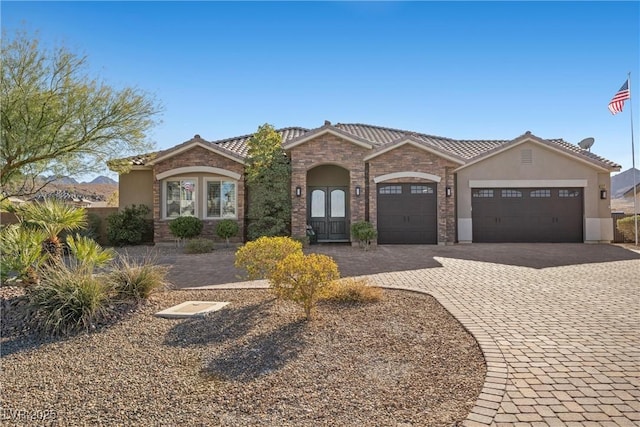 421 Foxhall Rd, Henderson, NV 89002 - mediterranean / spanish house with stucco siding, a tile roof, decorative driveway, brick siding, and a garage