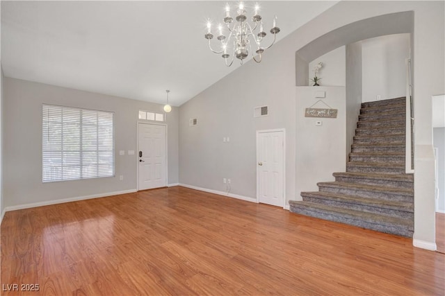 entryway with baseboards, visible vents, a chandelier, wood finished floors, and stairway