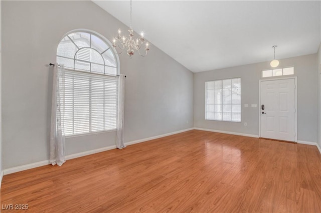 interior space featuring light wood-type flooring, baseboards, a wealth of natural light, and a chandelier