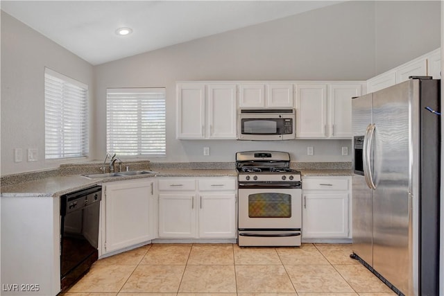 kitchen featuring a sink, light tile patterned floors, stainless steel appliances, lofted ceiling, and white cabinetry