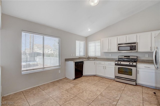 kitchen featuring stainless steel appliances, a sink, vaulted ceiling, white cabinetry, and light tile patterned floors