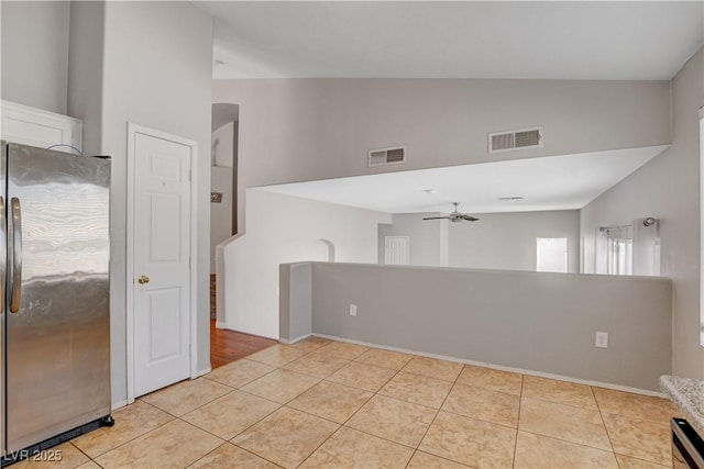 unfurnished room featuring high vaulted ceiling, a ceiling fan, visible vents, and light tile patterned floors