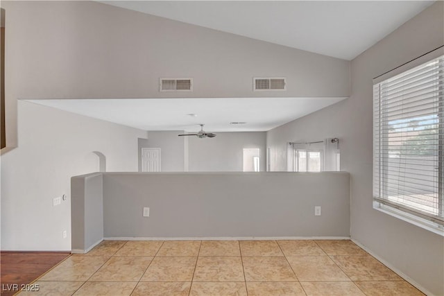 unfurnished room with lofted ceiling, baseboards, a ceiling fan, and visible vents
