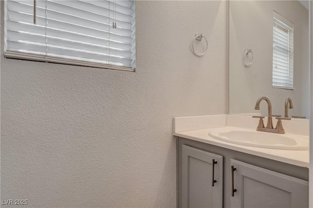 bathroom with a textured wall and vanity