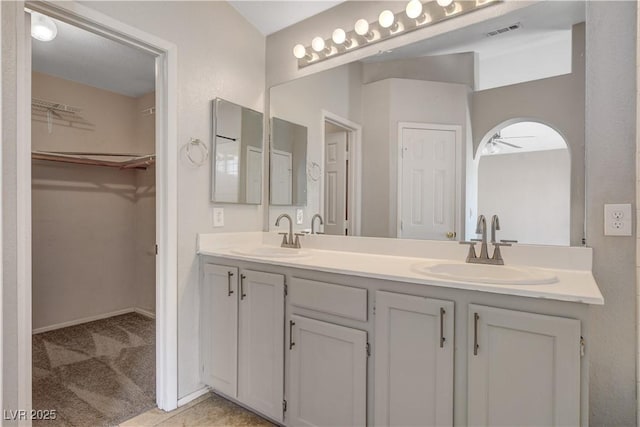full bathroom with ceiling fan, a sink, visible vents, and double vanity