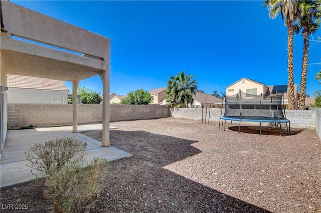 view of yard featuring a fenced backyard, a patio, and a trampoline