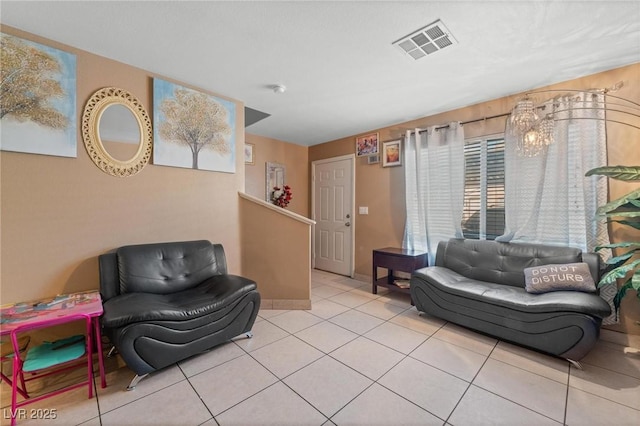 living area with tile patterned floors, visible vents, baseboards, and a healthy amount of sunlight