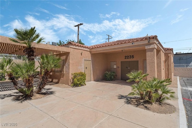 exterior space featuring stucco siding and a tiled roof