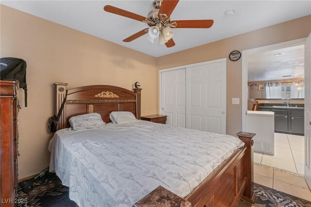 bedroom with light tile patterned floors, a closet, and ceiling fan