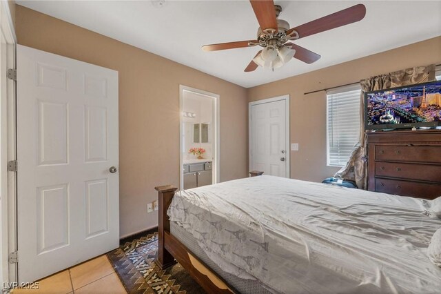 bedroom featuring ensuite bathroom, light tile patterned flooring, and a ceiling fan