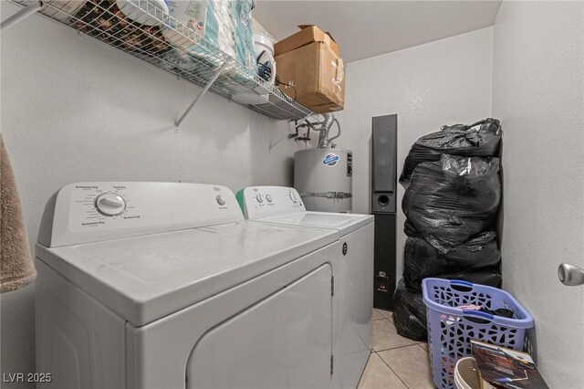 laundry room with electric water heater, light tile patterned floors, independent washer and dryer, and laundry area