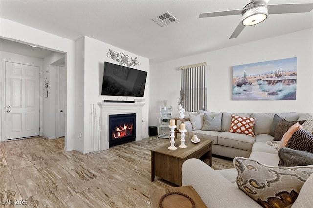10052 Silver Comet Ct, Las Vegas, NV 89178 - living area with ceiling fan, a glass covered fireplace, and light wood finished floors