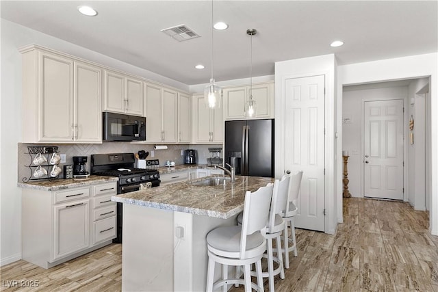 10052 Silver Comet Ct, Las Vegas, NV 89178 - kitchen with black microwave, stainless steel fridge with ice dispenser, a sink, a kitchen bar, and decorative backsplash